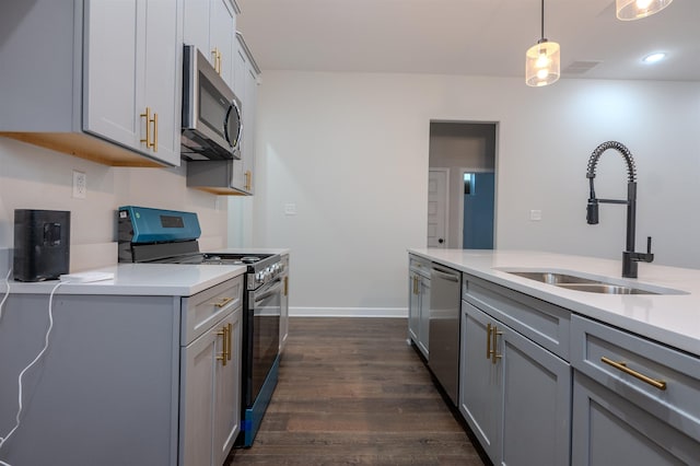 kitchen featuring gray cabinets, hanging light fixtures, and stainless steel appliances