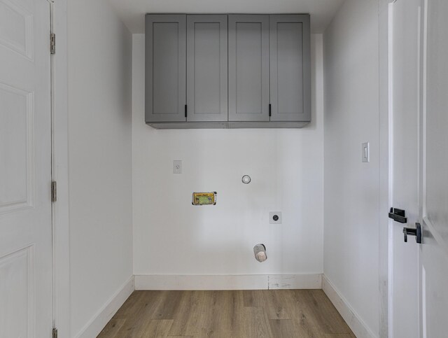 clothes washing area featuring hookup for an electric dryer, washer hookup, wood finished floors, and baseboards