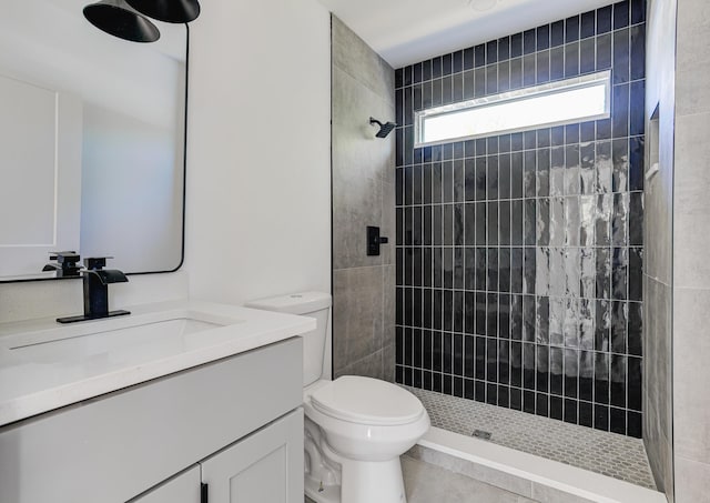bathroom featuring toilet, vanity, and tiled shower