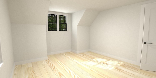 additional living space with vaulted ceiling and light hardwood / wood-style floors