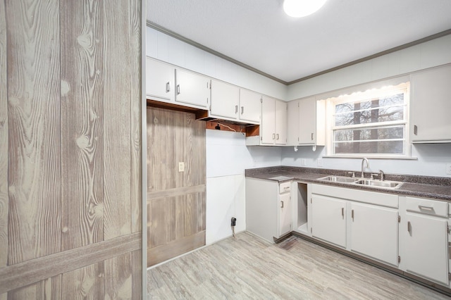 kitchen with sink, crown molding, light hardwood / wood-style flooring, and white cabinets