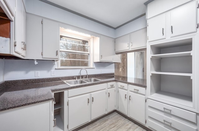 kitchen with sink, light hardwood / wood-style flooring, and white cabinets