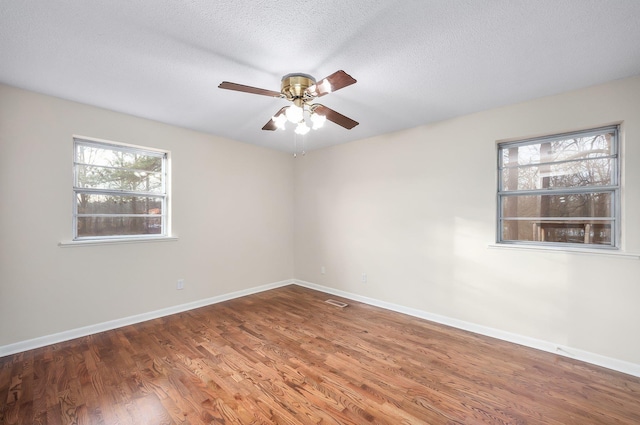 unfurnished room with ceiling fan, hardwood / wood-style floors, and a textured ceiling