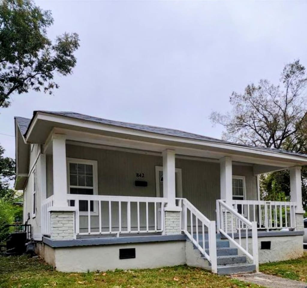 view of front of house with a front yard and covered porch