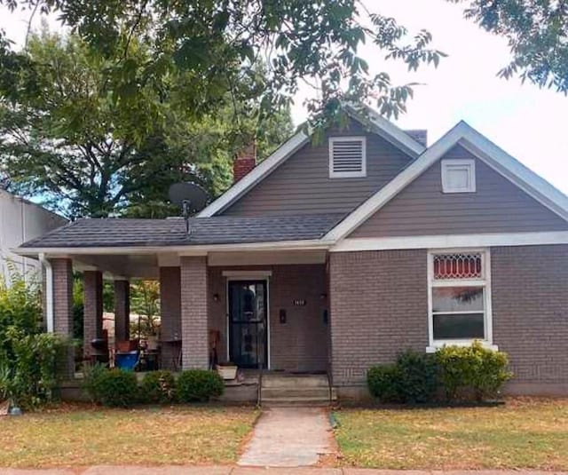 view of front of house with a front yard and covered porch