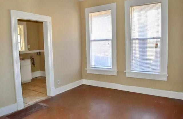 empty room with tile patterned flooring and a wealth of natural light