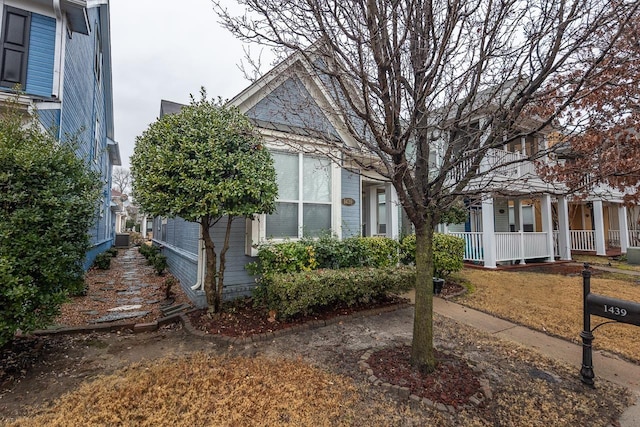 view of side of home with central AC and covered porch