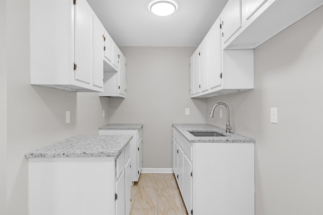 kitchen featuring sink and white cabinets