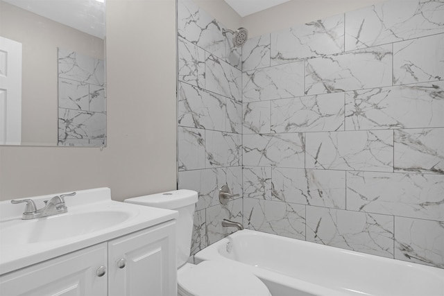 full bathroom with tiled shower / bath, vanity, and toilet