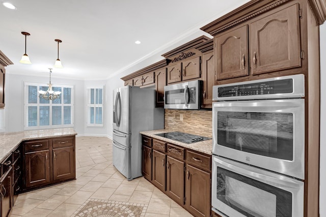 kitchen featuring pendant lighting, backsplash, stainless steel appliances, crown molding, and light stone countertops