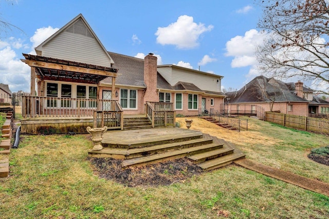 back of property featuring a wooden deck and a lawn