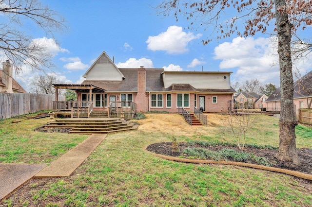 back of house featuring a deck and a lawn