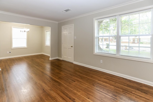 unfurnished room featuring dark wood-type flooring, ornamental molding, and a chandelier