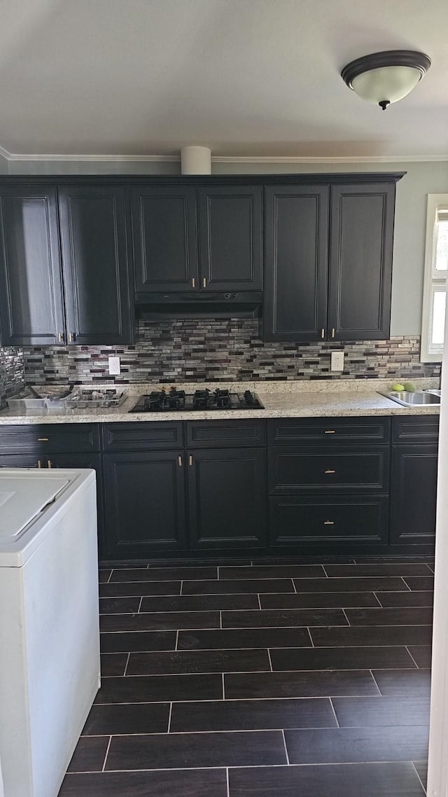 kitchen with sink, ornamental molding, light stone countertops, decorative backsplash, and black gas stovetop