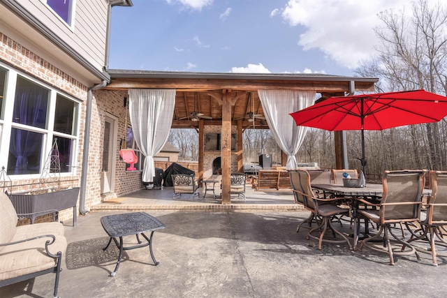 view of patio / terrace with ceiling fan and an outdoor stone fireplace