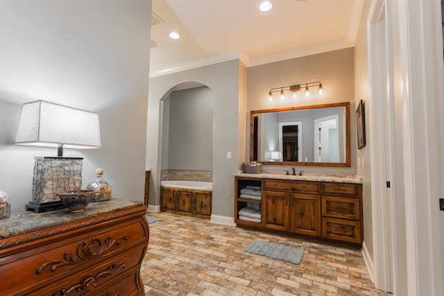 bathroom featuring vanity, a washtub, and crown molding