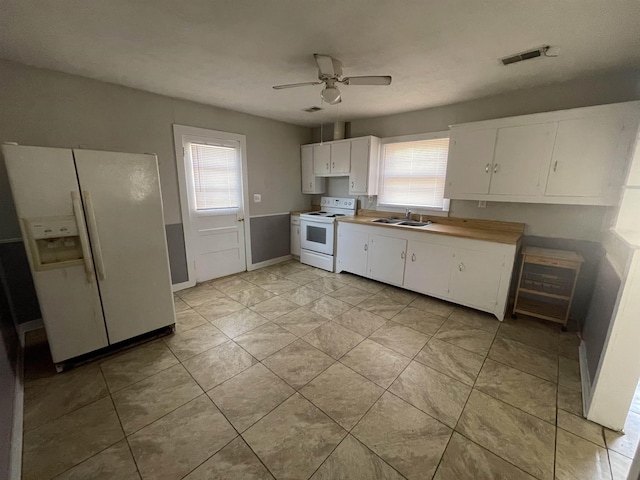 kitchen with sink, white cabinetry, light tile patterned floors, ceiling fan, and white appliances