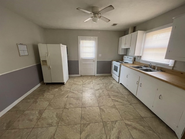 kitchen featuring sink, white cabinets, light tile patterned floors, ceiling fan, and white appliances