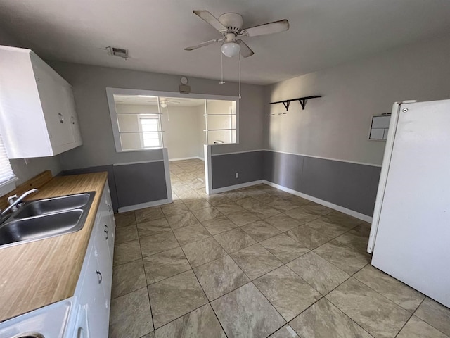 kitchen featuring white cabinetry, white fridge, sink, and ceiling fan