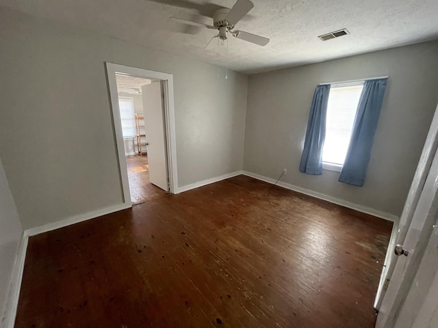 unfurnished room with dark wood-type flooring, ceiling fan, and a textured ceiling