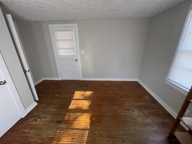 empty room featuring dark hardwood / wood-style flooring and a textured ceiling