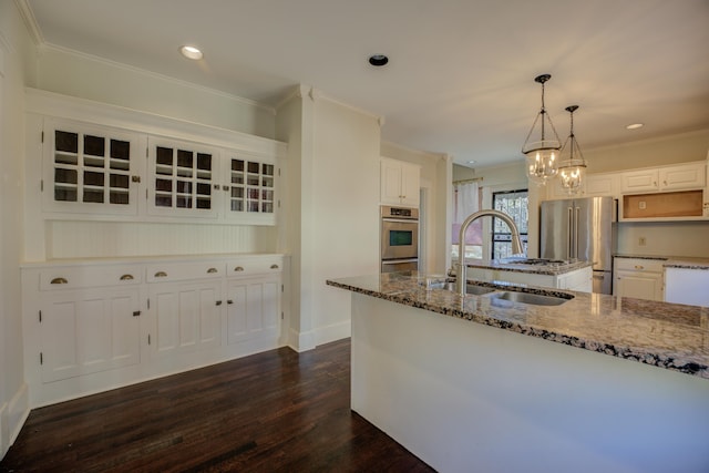 kitchen with decorative light fixtures, white cabinetry, sink, stainless steel appliances, and crown molding