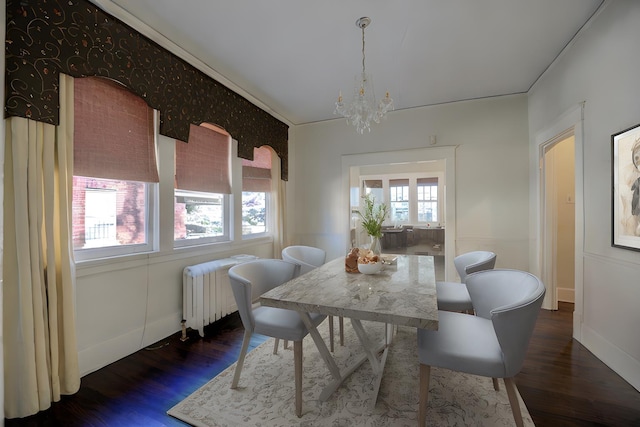 dining area with crown molding, radiator, dark wood-type flooring, and a notable chandelier