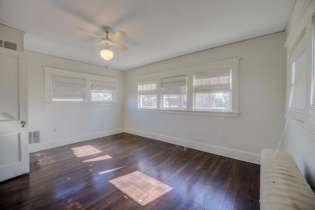 empty room with radiator, dark wood-type flooring, and ceiling fan