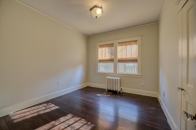 empty room with radiator, crown molding, and dark hardwood / wood-style floors