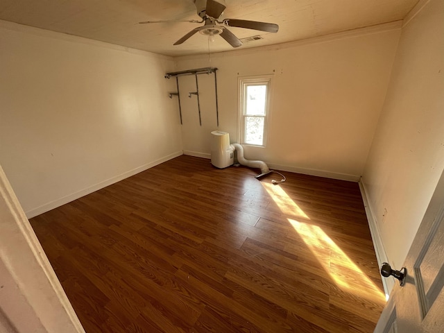 empty room featuring ceiling fan, ornamental molding, and dark hardwood / wood-style floors