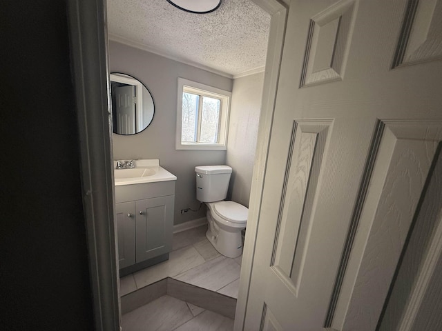 bathroom featuring vanity, toilet, crown molding, tile patterned floors, and a textured ceiling