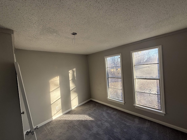 carpeted empty room featuring a textured ceiling