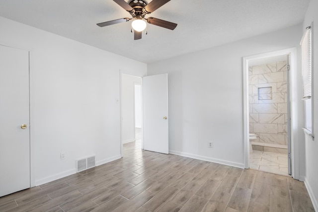 unfurnished bedroom featuring ceiling fan and ensuite bath