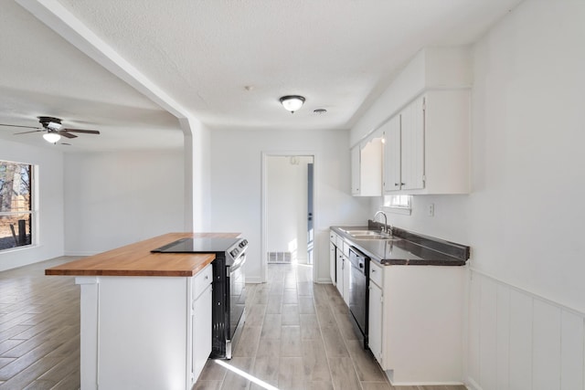 kitchen with range with electric stovetop, dishwasher, wooden counters, white cabinets, and a textured ceiling