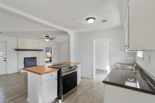 kitchen featuring white cabinetry, butcher block counters, sink, and electric range