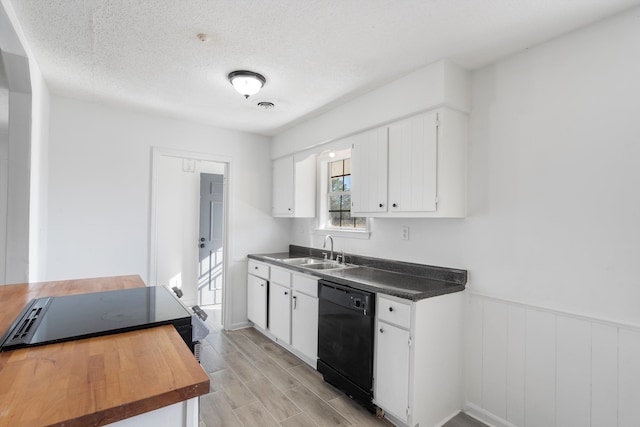 kitchen featuring white cabinetry, dishwasher, sink, and a textured ceiling