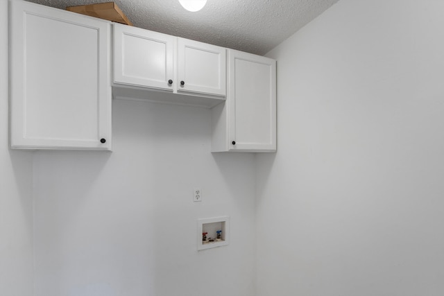 laundry room featuring cabinets, washer hookup, and a textured ceiling