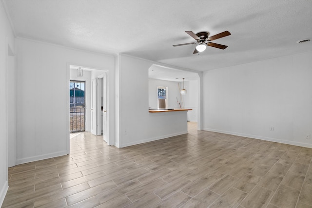 unfurnished living room featuring ornamental molding and ceiling fan