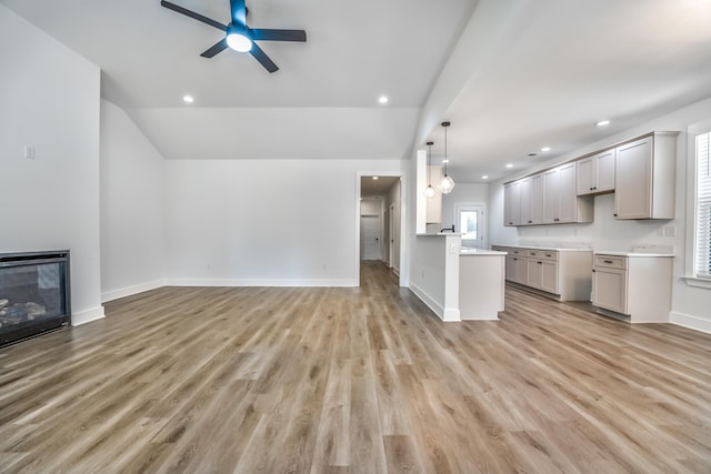 unfurnished living room with vaulted ceiling, light hardwood / wood-style floors, and ceiling fan