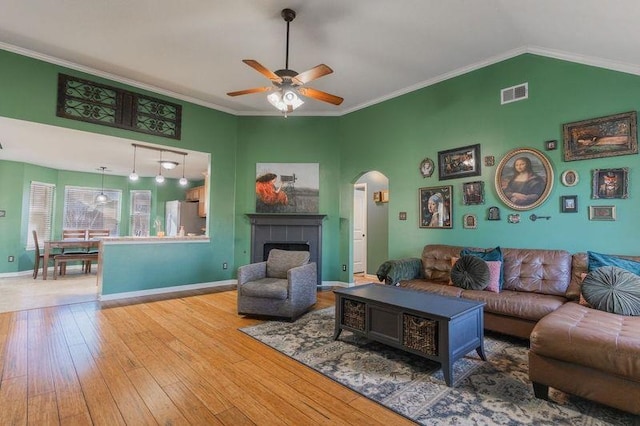 living room featuring crown molding, vaulted ceiling, ceiling fan, and hardwood / wood-style flooring