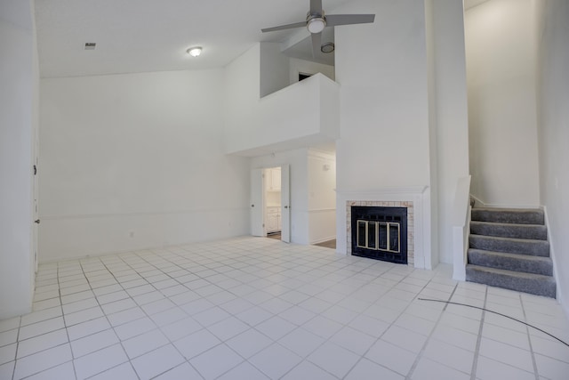 unfurnished living room with light tile patterned floors, high vaulted ceiling, and ceiling fan