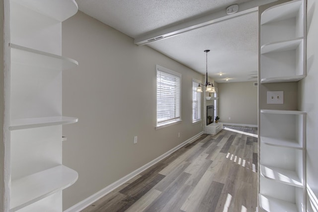 dining space featuring wood-type flooring, a chandelier, and a textured ceiling