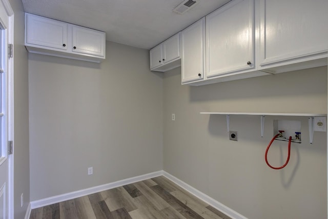 washroom featuring cabinets, hookup for a washing machine, light hardwood / wood-style flooring, and electric dryer hookup