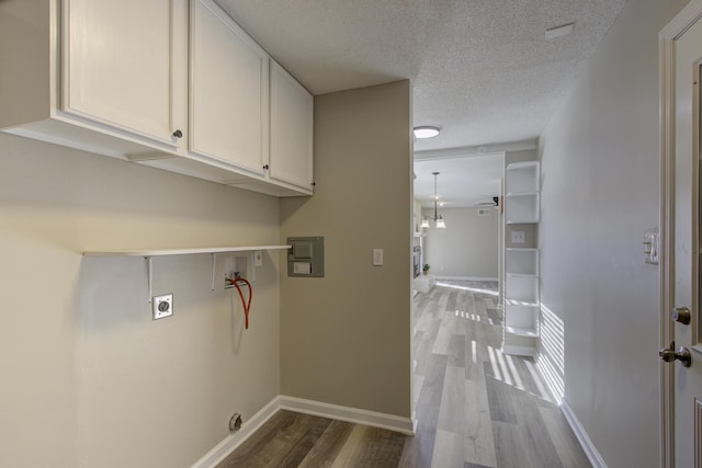 washroom featuring hardwood / wood-style floors, cabinets, washer hookup, hookup for an electric dryer, and a textured ceiling