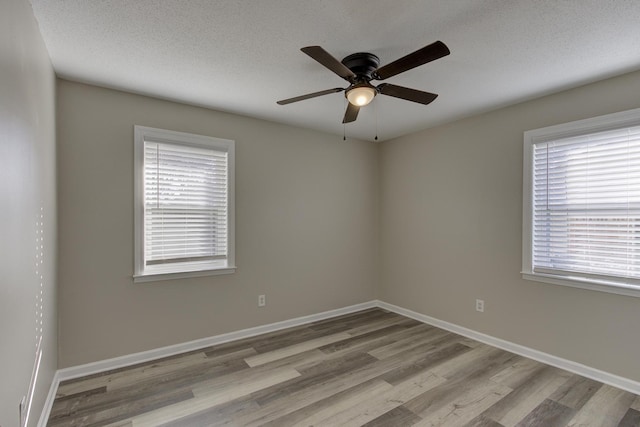 unfurnished room featuring ceiling fan, light hardwood / wood-style flooring, and a textured ceiling