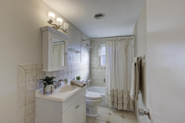 full bathroom with vanity, toilet, tile patterned floors, a textured ceiling, and shower / bath combo with shower curtain