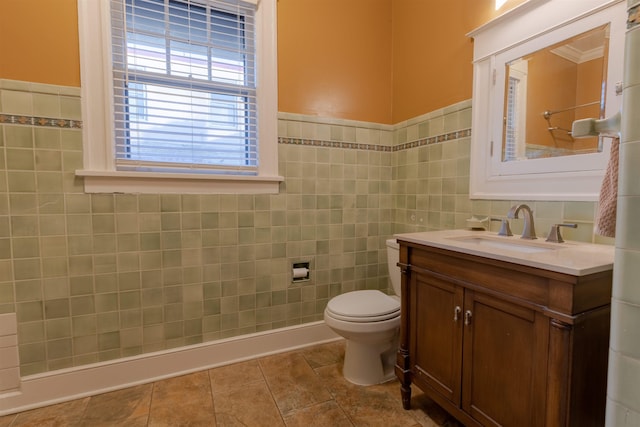 bathroom with tile patterned floors, toilet, tile walls, and vanity