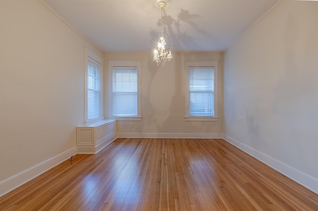 spare room featuring a notable chandelier and hardwood / wood-style flooring