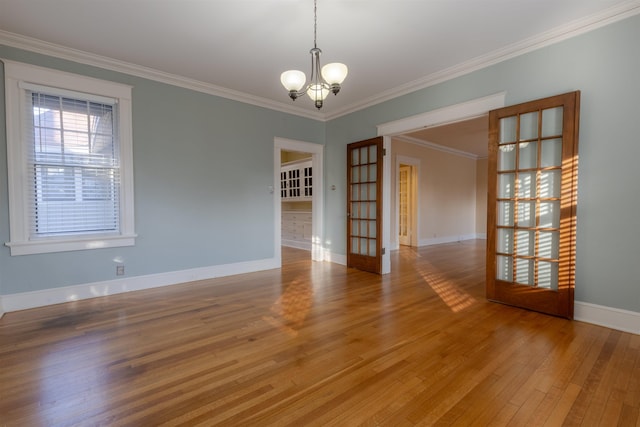 unfurnished room with hardwood / wood-style flooring, ornamental molding, and a chandelier