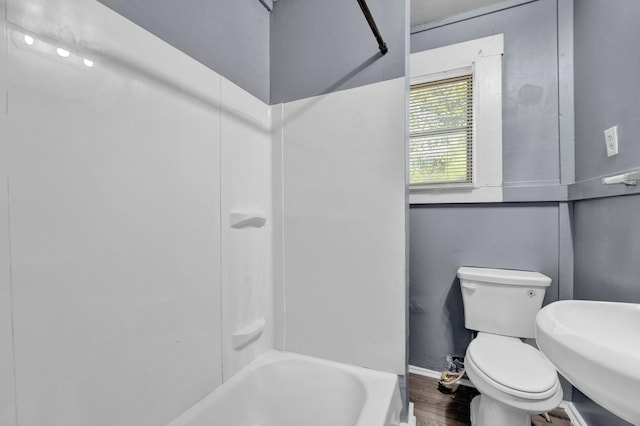 full bathroom with washtub / shower combination, toilet, and sink